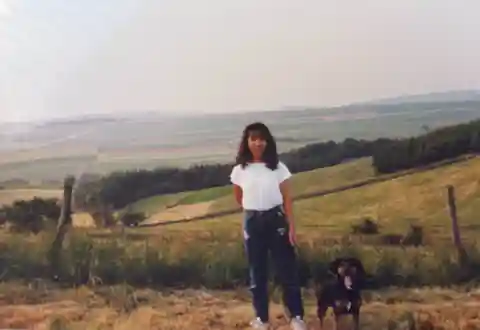 Tomoko standing outdoors in Melbach, Germany, beside Lady, with a rural hillside behind them.